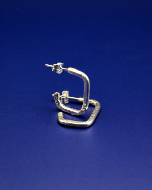 925 Silver oblong hoop earrings on a blue background.